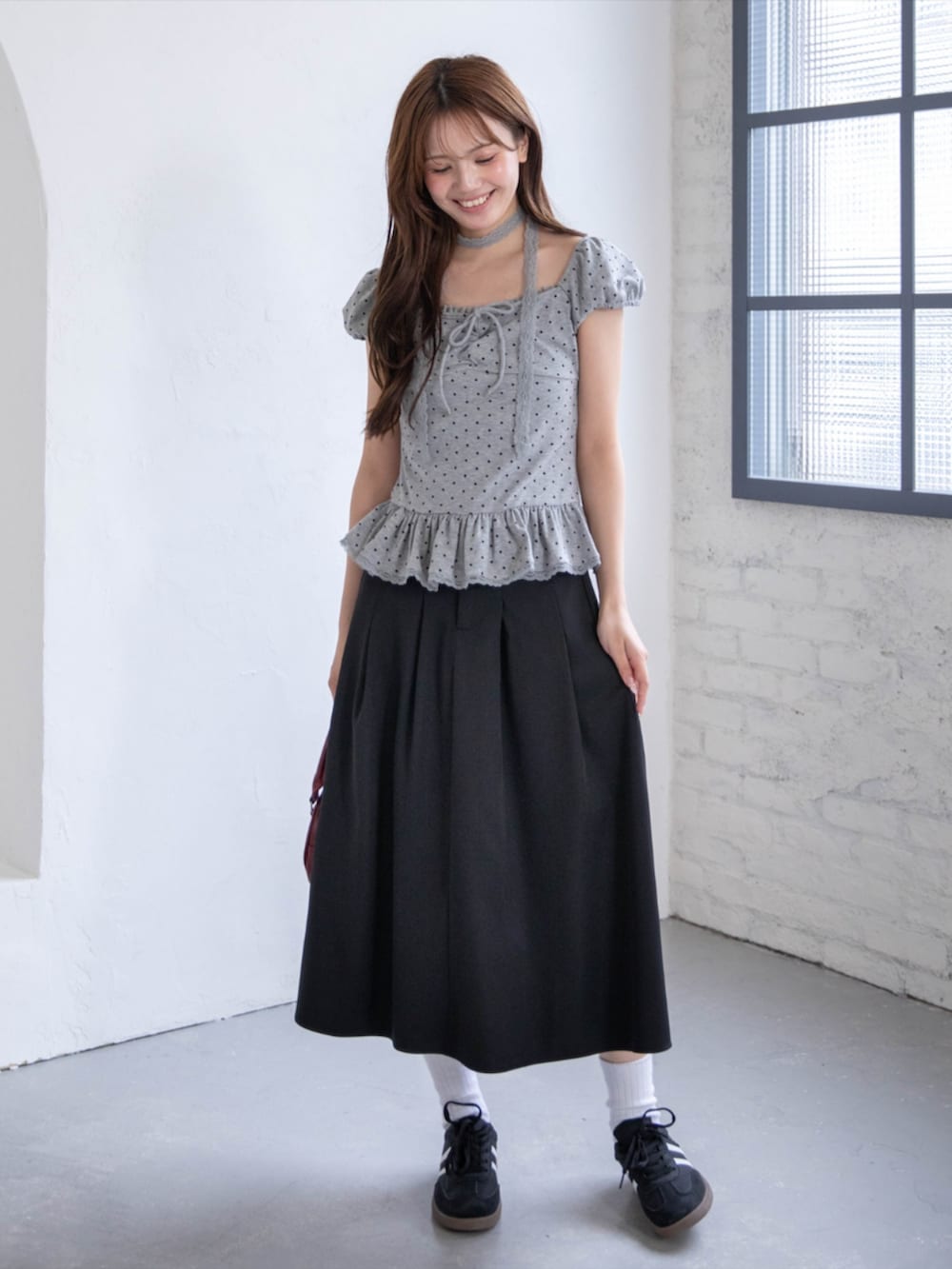 ブラック系のスニーカー、グレー系のTシャツ/カットソー、ブラック系のスカートを着用したレディースの春コーディネートの2枚目の写真