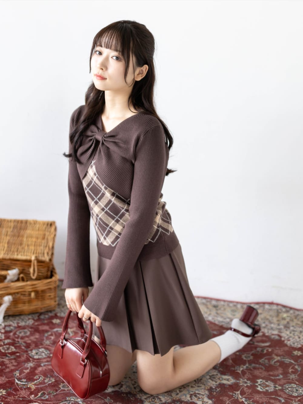 レッド系のパンプス、ブラウン系のスカート、ブラウン系のニット/セーターを着用したレディースの秋コーディネートの4枚目の写真