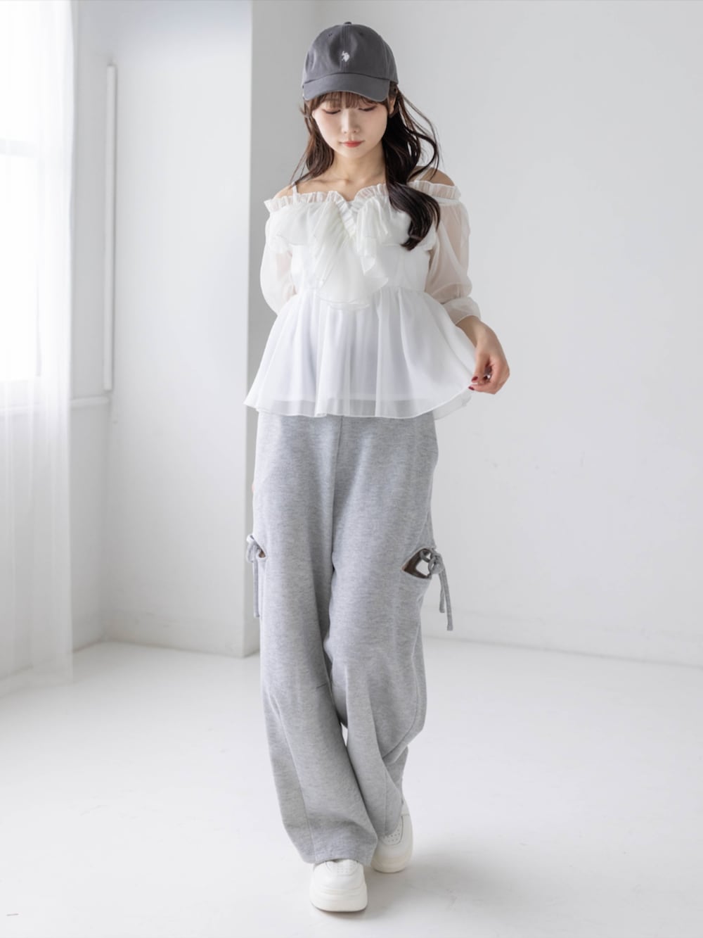 グレー系のスウェットパンツ、ホワイト系のシャツ/ブラウス、グレー系のキャップを着用したレディースの春コーディネートの2枚目の写真