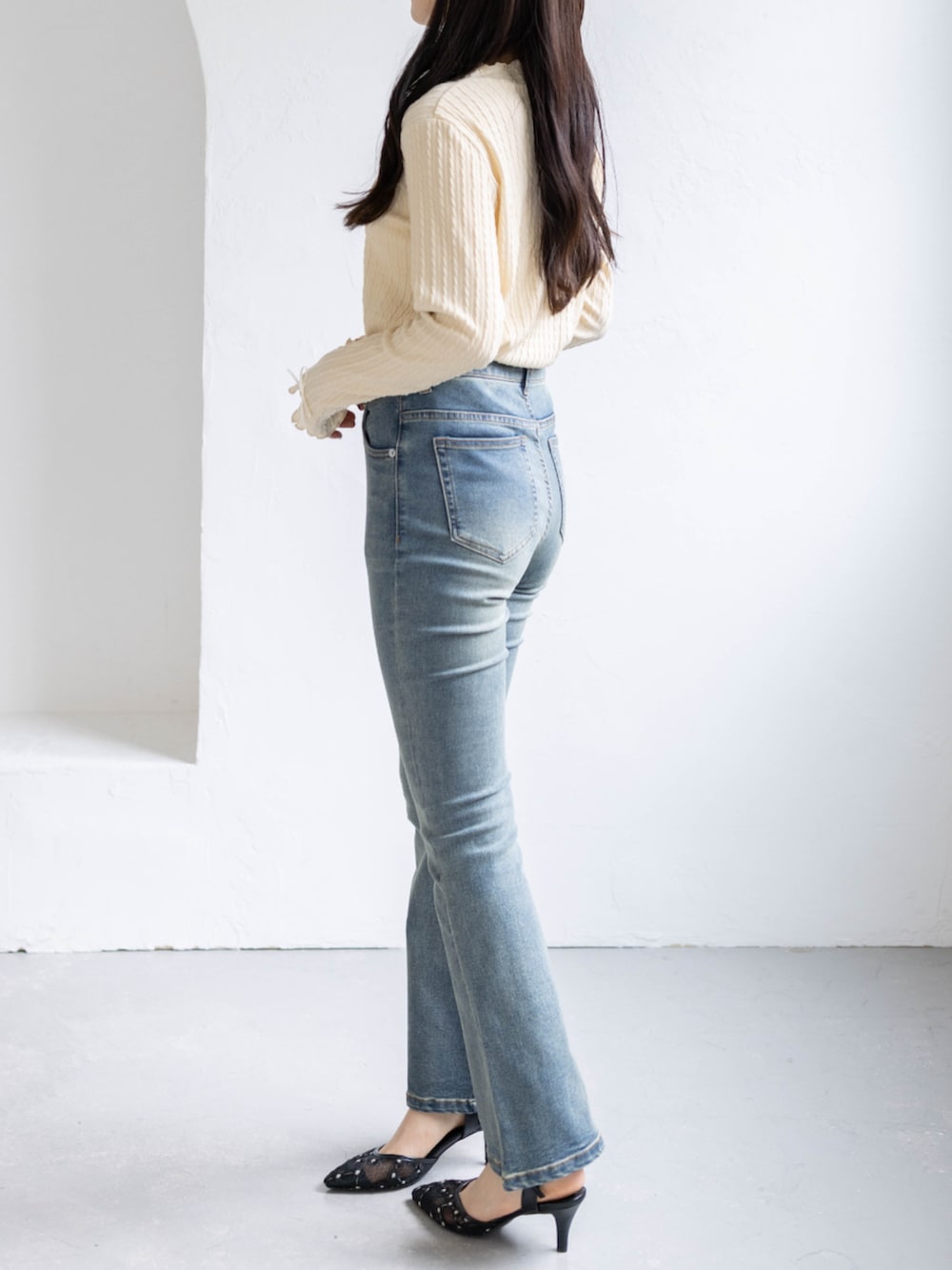 ブルー系のデニムパンツ、ベージュ系のTシャツ/カットソー、ブラック系のパンプスを着用したレディースの春コーディネートの3枚目の写真