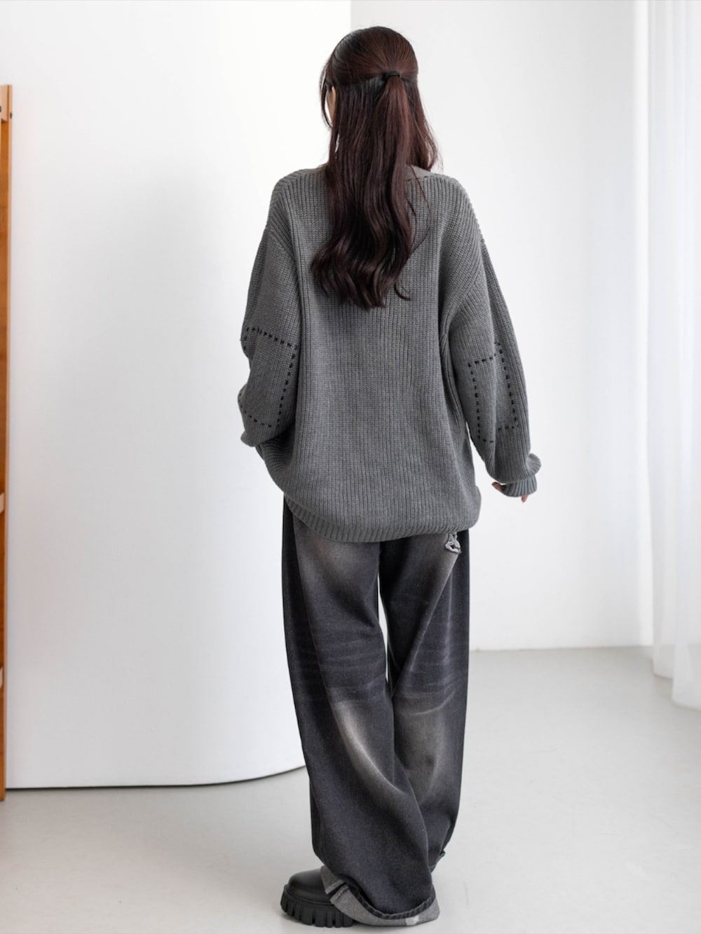 ブラック系のTシャツ/カットソー、ブラック系のデニムパンツ、ブラック系のブーツを着用したレディースの秋コーディネートの3枚目の写真