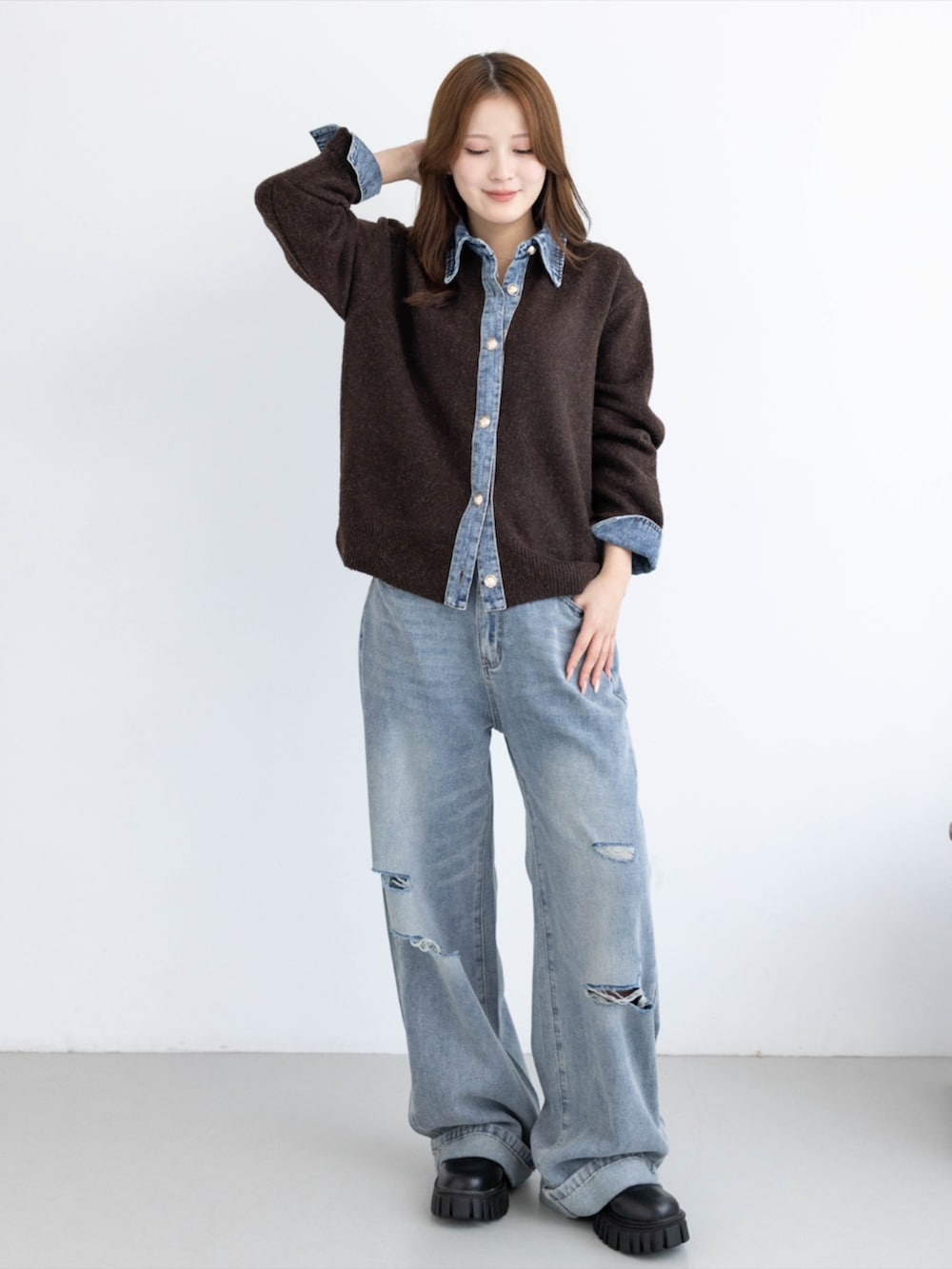 ブルー系のデニムパンツ、ブラック系のブーツ、ブラウン系のニット/セーターを着用したレディースの秋コーディネートの3枚目の写真