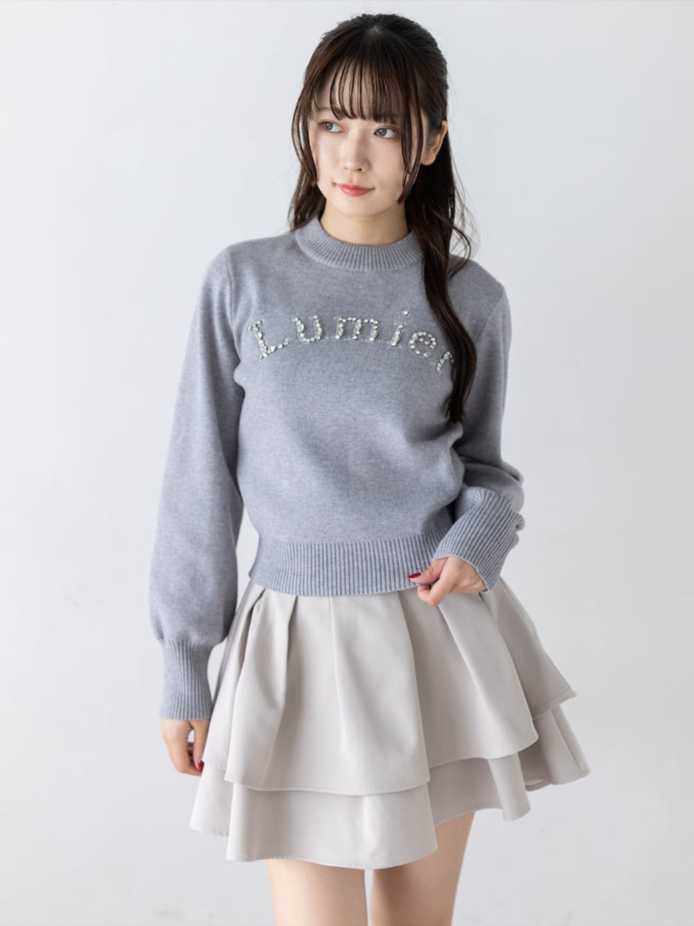 ブラック系のローファー、グレー系のニット/セーター、ベージュ系のスカートを着用したレディースの秋コーディネートの6枚目の写真