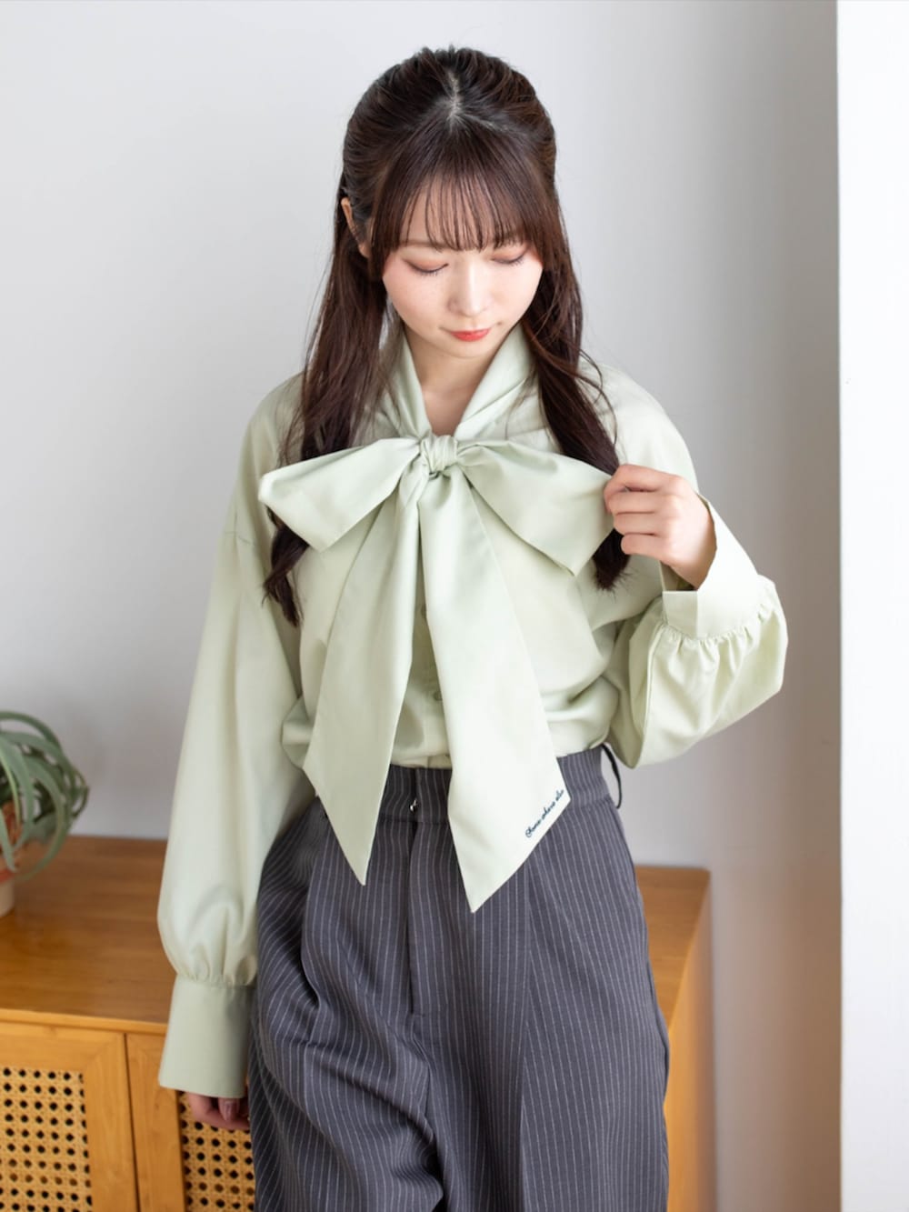 ブラック系のパンプス、グレー系のスラックス、グリーン系のシャツ/ブラウスを着用したレディースの夏コーディネートの7枚目の写真