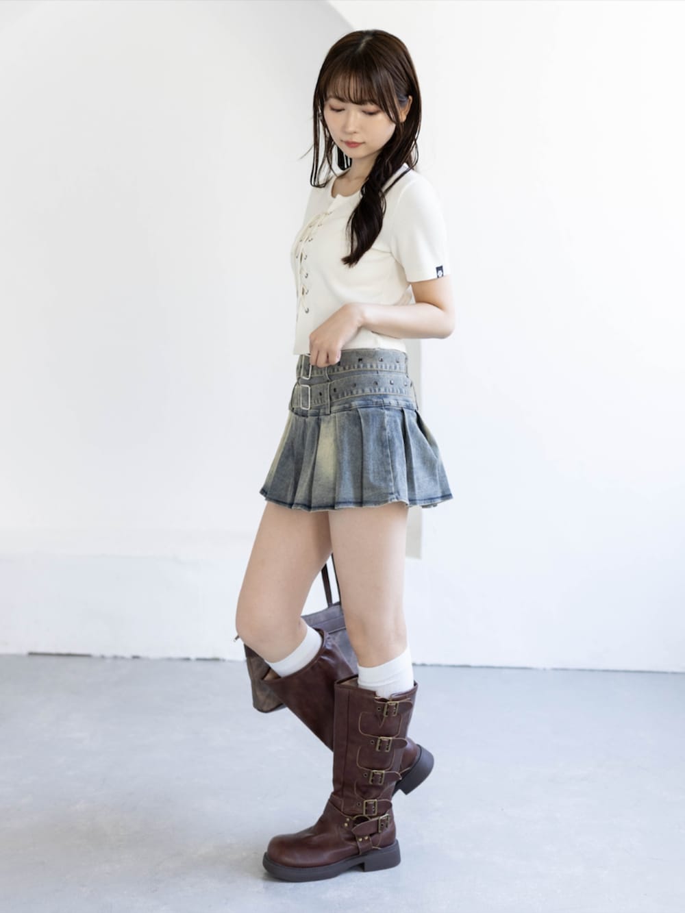 ブルー系のスカート、ホワイト系のTシャツ/カットソー、ブラウン系のショルダーバッグを着用したレディースの夏コーディネートの3枚目の写真