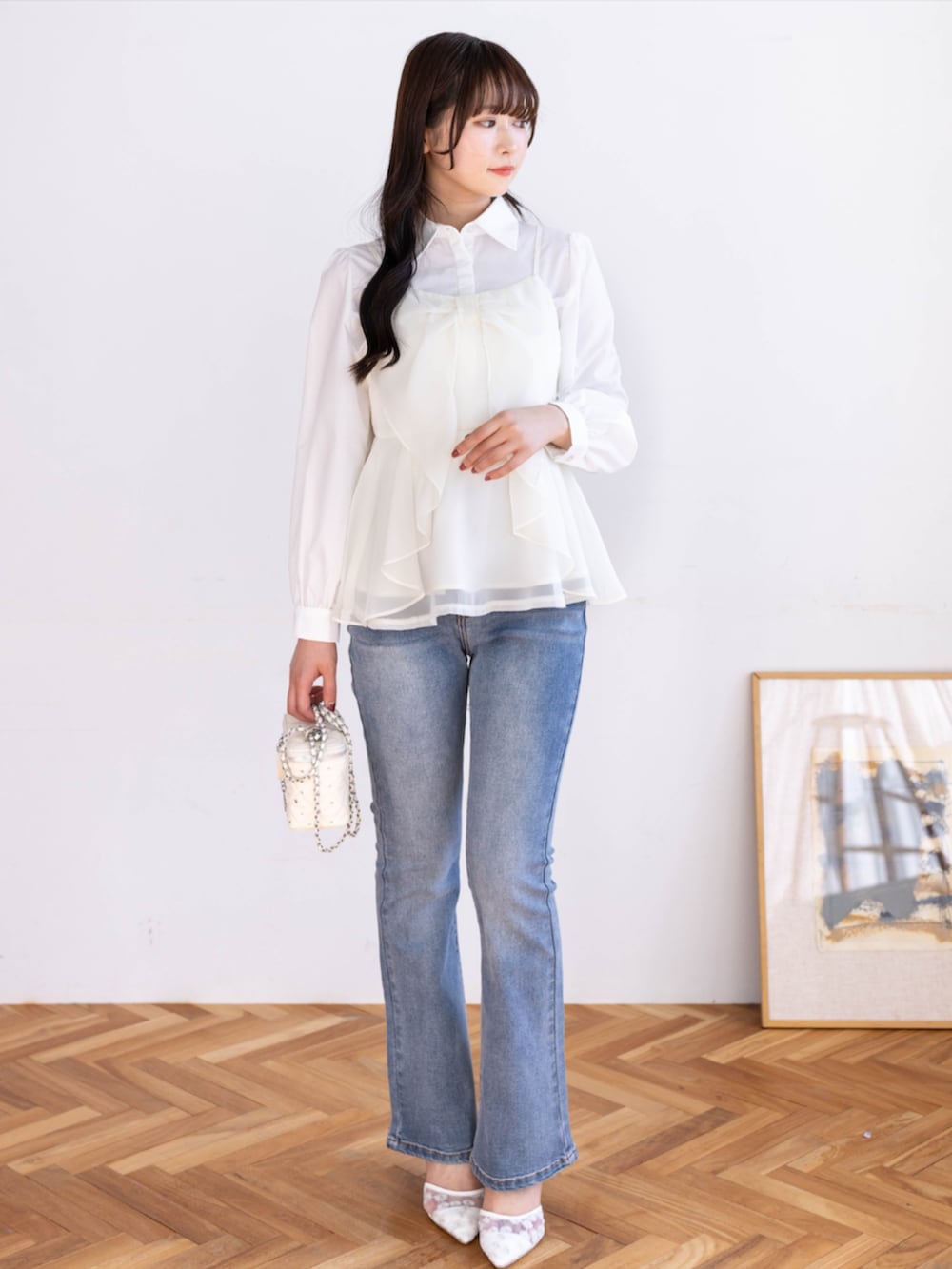 ブルー系のデニムパンツ、ホワイト系のシャツ/ブラウス、ホワイト系のパンプスを着用したレディースの春コーディネートの2枚目の写真