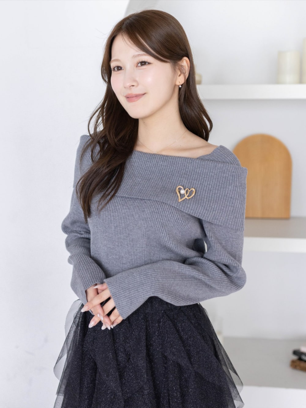 ブラック系のパンプス、ブラック系のスカート、グレー系のニット/セーターを着用したレディースの秋コーディネートの4枚目の写真