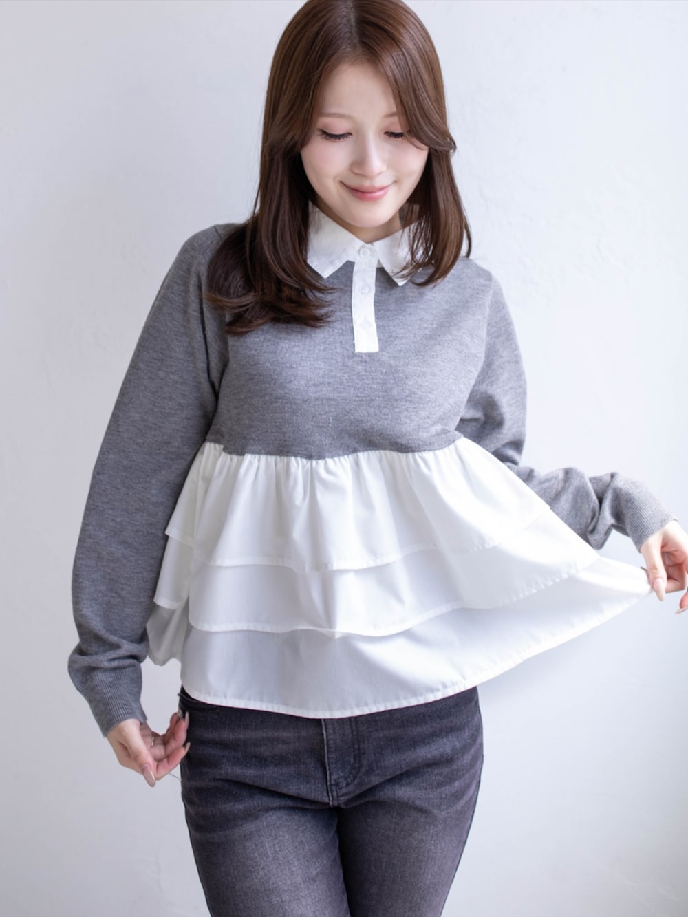 ブラック系のデニムパンツ、ブラック系のパンプス、グレー系のニット/セーターを着用したレディースの秋コーディネートの5枚目の写真