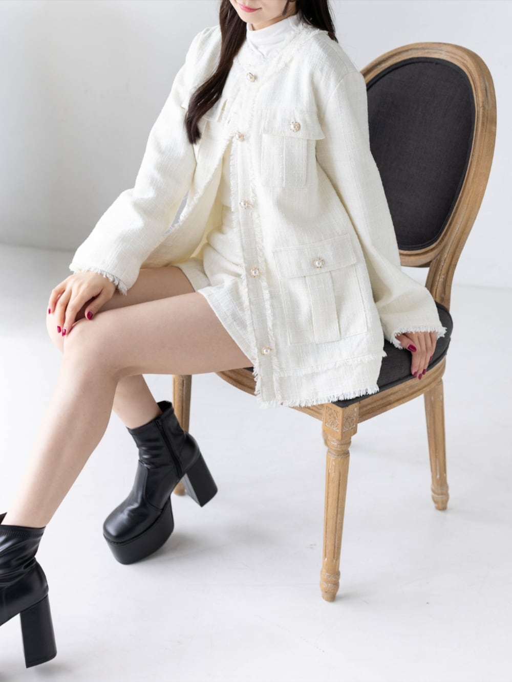 ホワイト系のTシャツ/カットソー、ブラック系のブーツ、ホワイト系のノーカラージャケットを着用したレディースの秋コーディネートの4枚目の写真