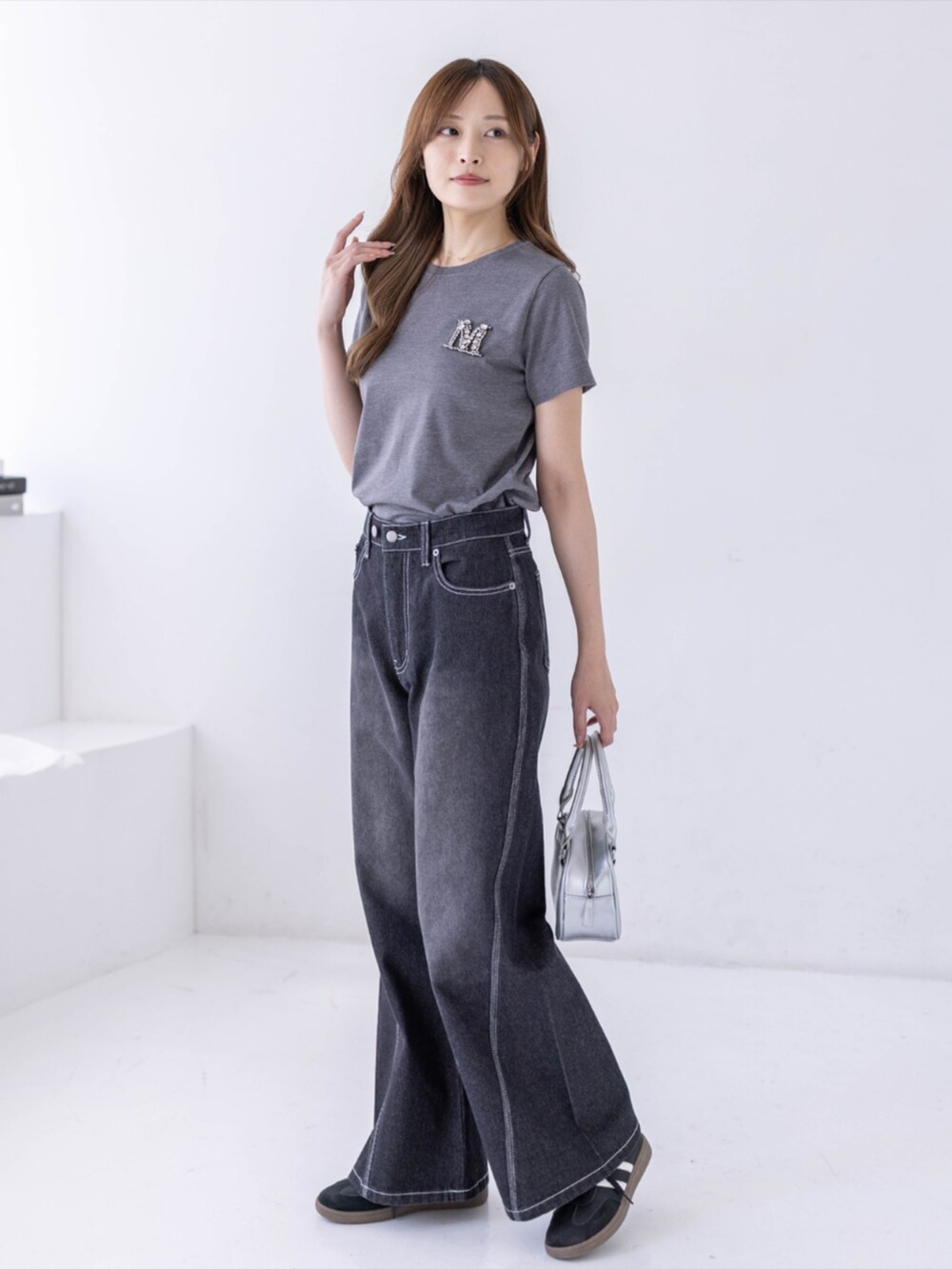 ブラック系のスニーカー、ブラック系のデニムパンツ、グレー系のTシャツ/カットソーを着用したレディースの春コーディネートの2枚目の写真