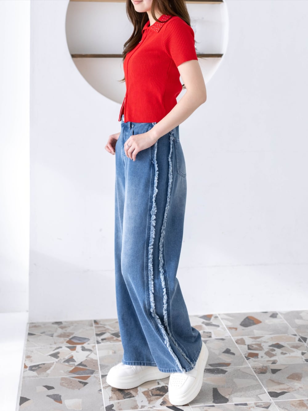 ブルー系のデニムパンツ、レッド系のニット/セーターを着用したレディースの夏コーディネートの2枚目の写真
