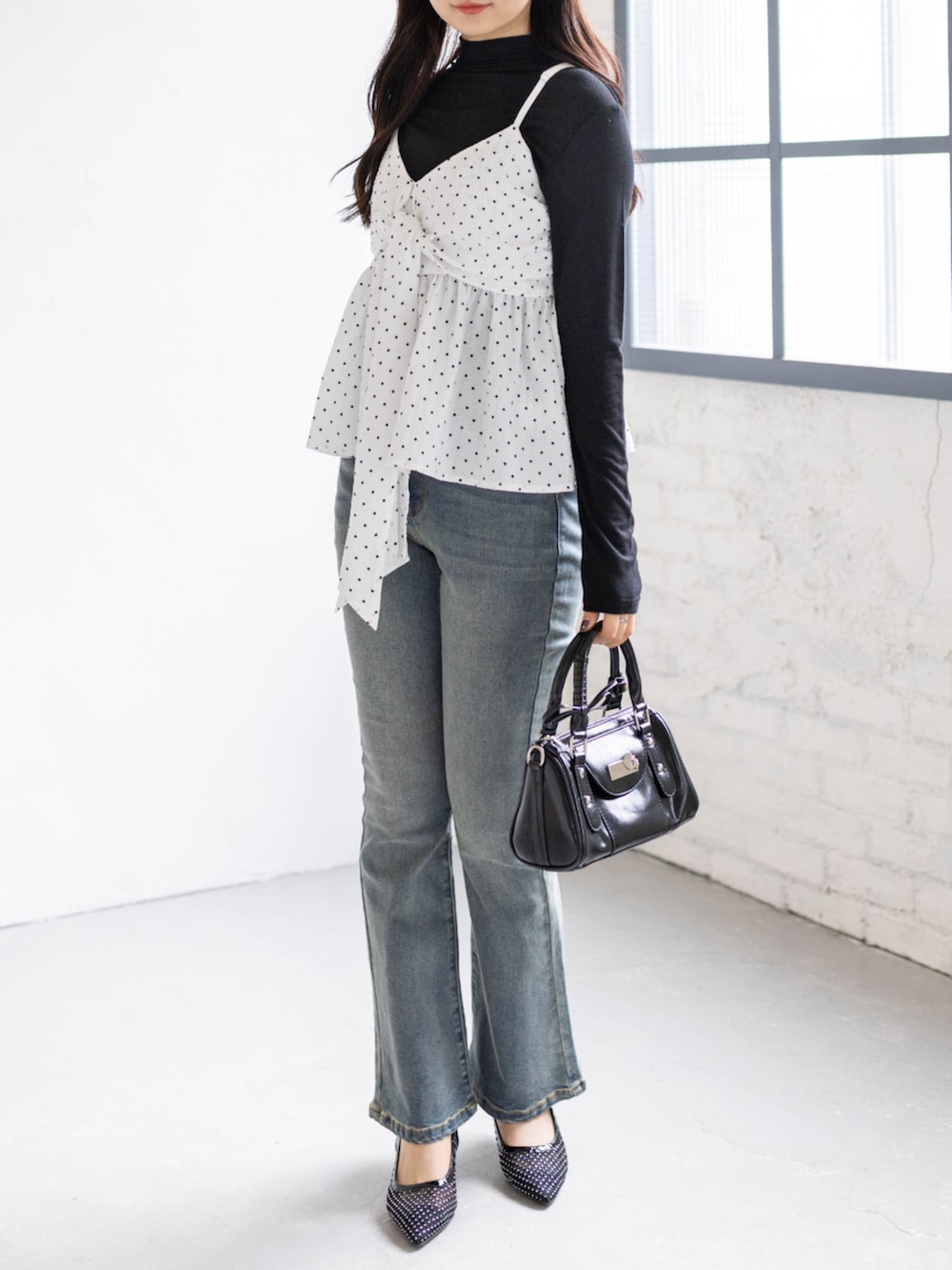 ブルー系のデニムパンツ、ブラック系のパンプス、ホワイト系のキャミソールを着用したレディースの春コーディネートの2枚目の写真