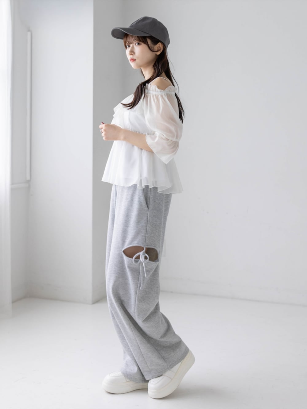 グレー系のスウェットパンツ、ホワイト系のシャツ/ブラウス、グレー系のキャップを着用したレディースの春コーディネートの3枚目の写真