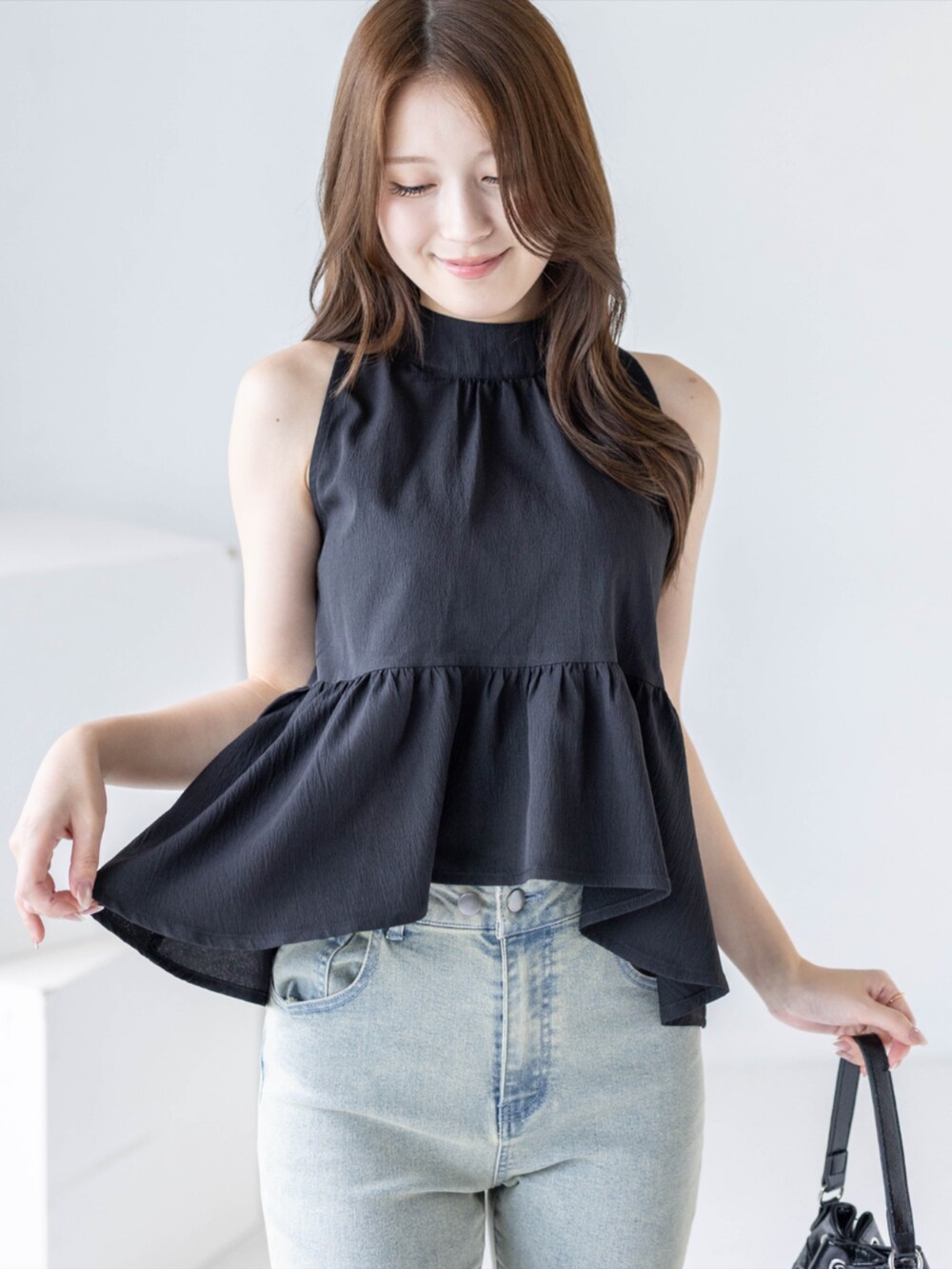 ブラック系のパンプス、ブルー系のデニムパンツ、ブラック系のシャツ/ブラウスを着用したレディースの夏コーディネートの4枚目の写真