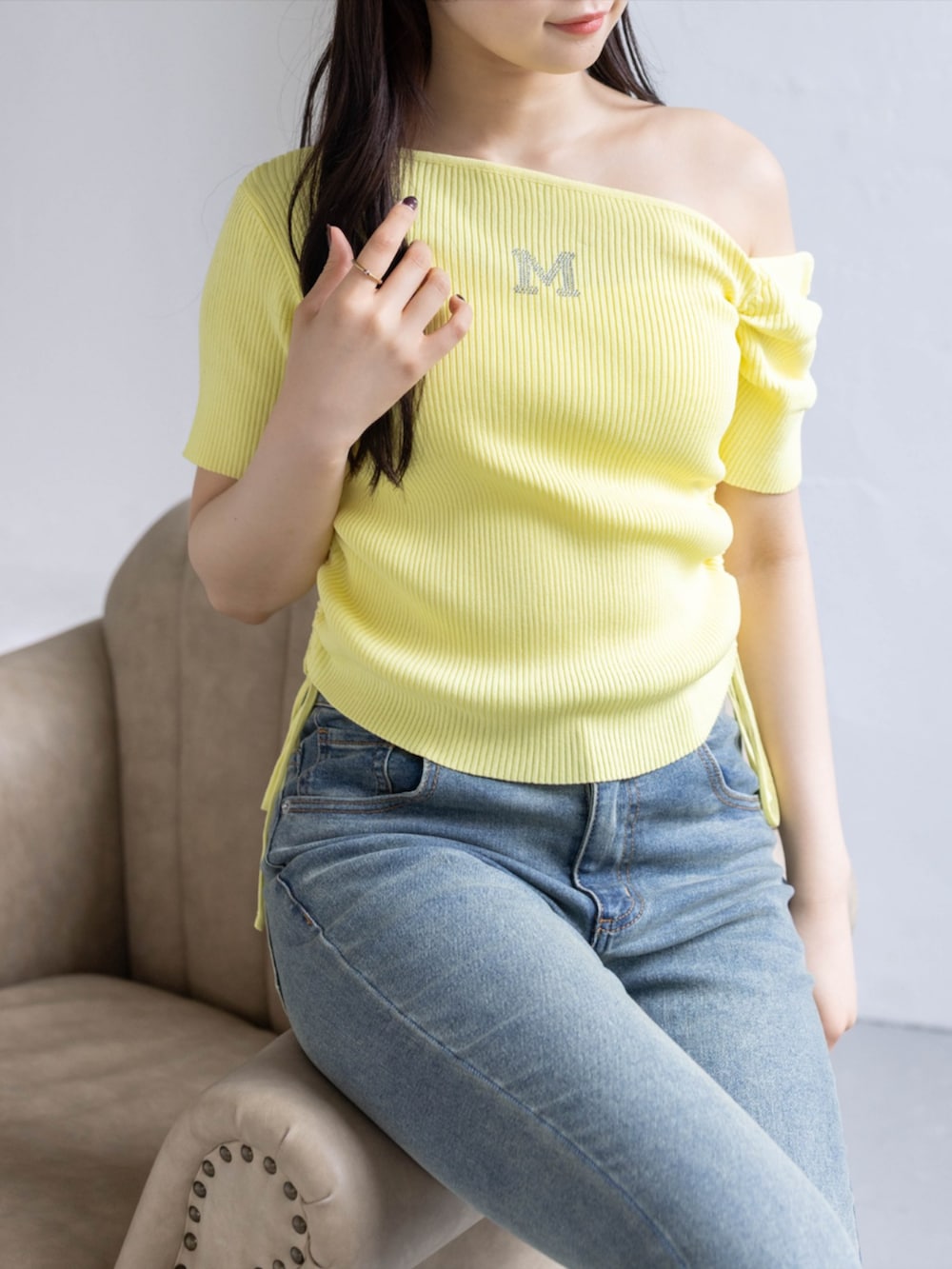 ホワイト系のスニーカー、ブルー系のデニムパンツ、イエロー系のニット/セーターを着用したレディースの春コーディネートの4枚目の写真