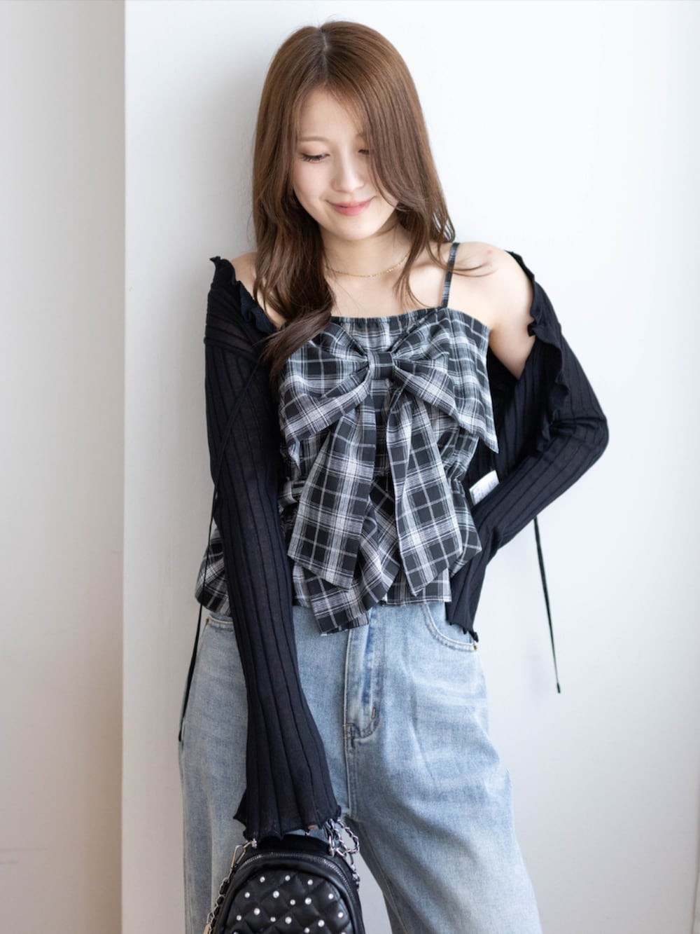 ブラック系のパンプス、ブラック系のカーディガン/ボレロ、ブルー系のデニムパンツを着用したレディースの夏コーディネートの4枚目の写真