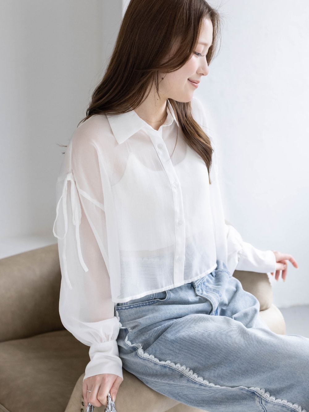 ブルー系のデニムパンツ、ホワイト系のパンプス、ホワイト系のシャツ/ブラウスを着用したレディースの春コーディネートの3枚目の写真