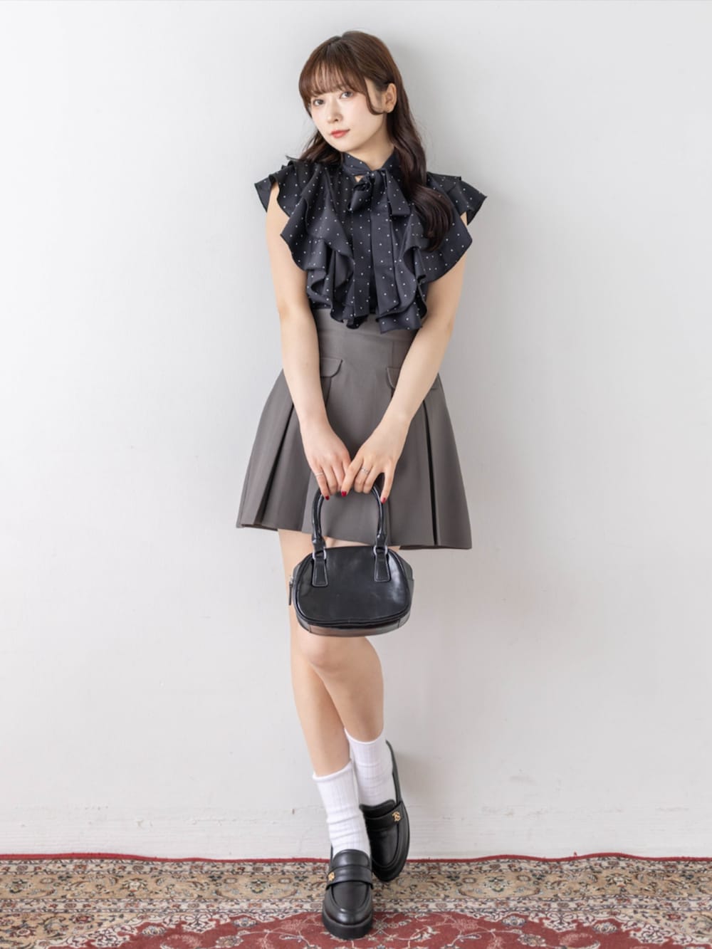 ブラック系のローファー、ブラック系のシャツ/ブラウス、グレー系のスカートを着用したレディースの春コーディネートの3枚目の写真