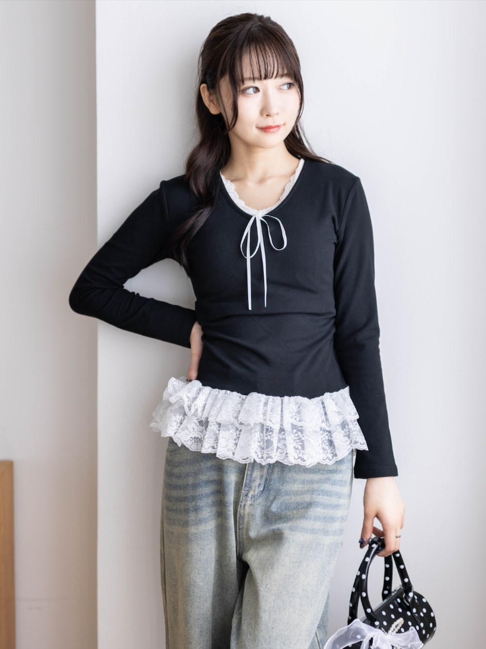 ブラック系のパンプス、ブラック系のボストンバッグ、ブルー系のデニムパンツを着用したレディースの夏コーディネートの4枚目の写真
