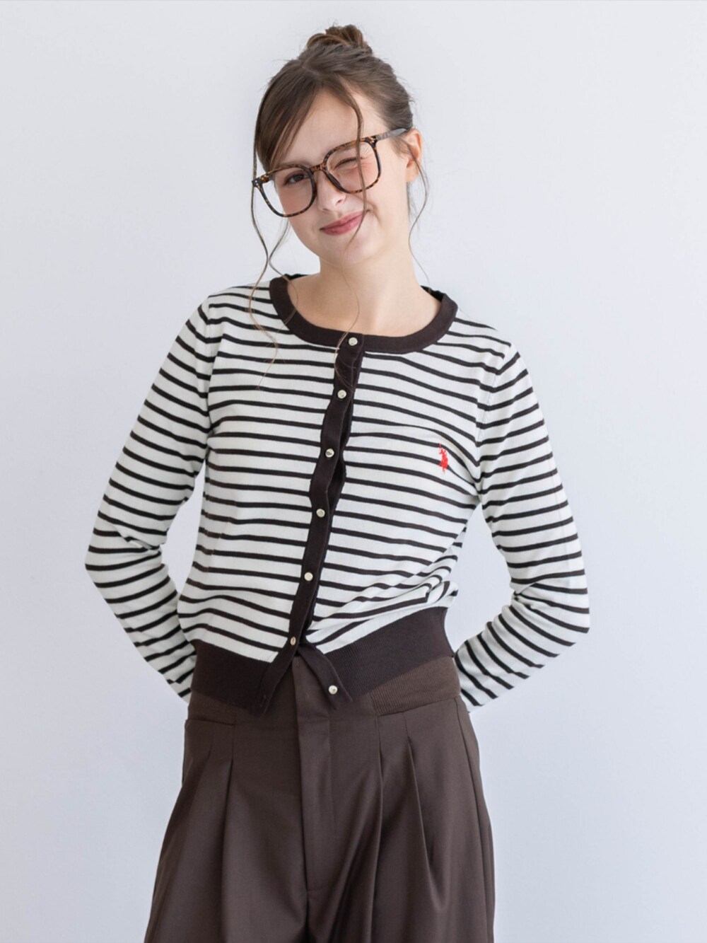 レッド系のパンプス、ブラウン系のスラックス、ブラウン系のカーディガン/ボレロを着用したレディースの夏コーディネートの5枚目の写真