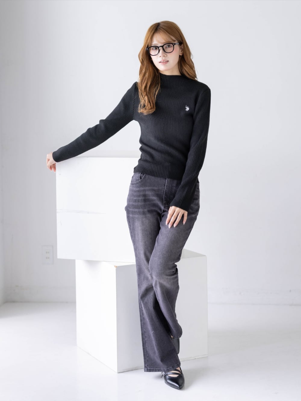 ブラック系のデニムパンツ、ブラック系のパンプス、ブラック系のニット/セーターを着用したレディースの秋コーディネートの2枚目の写真