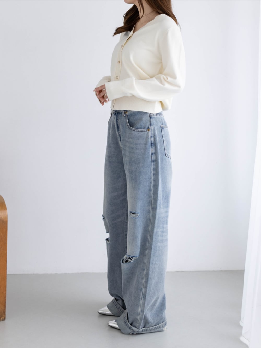 シルバー系のパンプス、ブルー系のデニムパンツ、ホワイト系のカーディガン/ボレロを着用したレディースの秋コーディネートの4枚目の写真