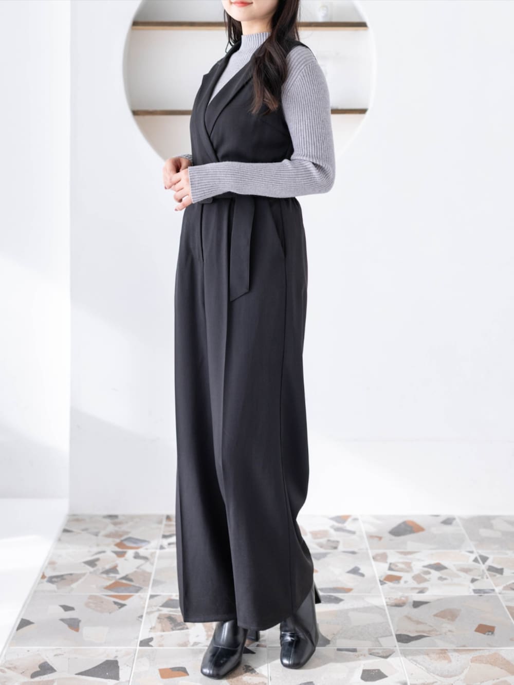 グレー系のニット/セーター、ブラック系のつなぎ/オールインワンを着用したレディースの夏コーディネートの3枚目の写真
