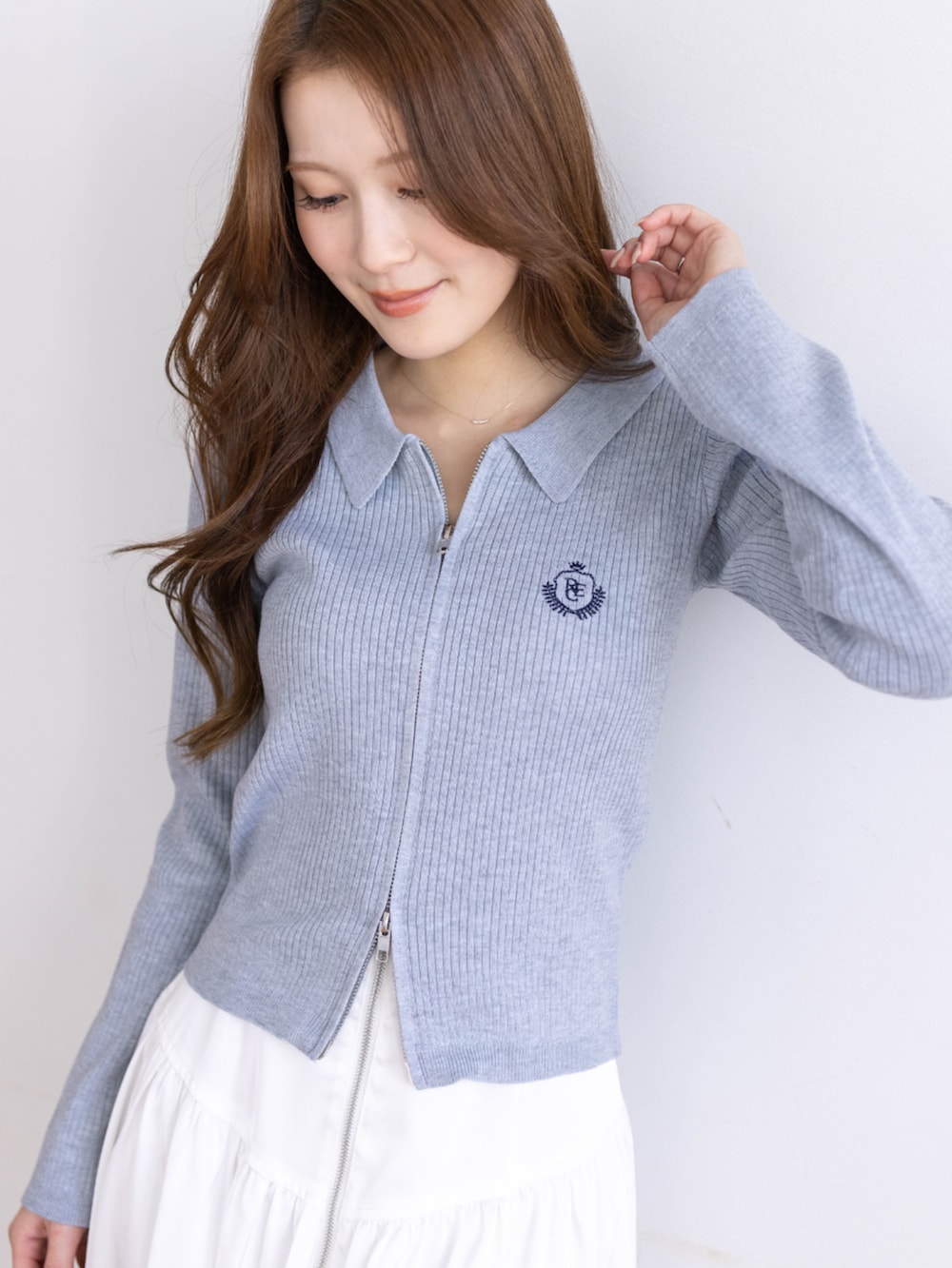 ブラック系のブーツ、グレー系のニット/セーター、ホワイト系のスカートを着用したレディースの冬コーディネートの4枚目の写真