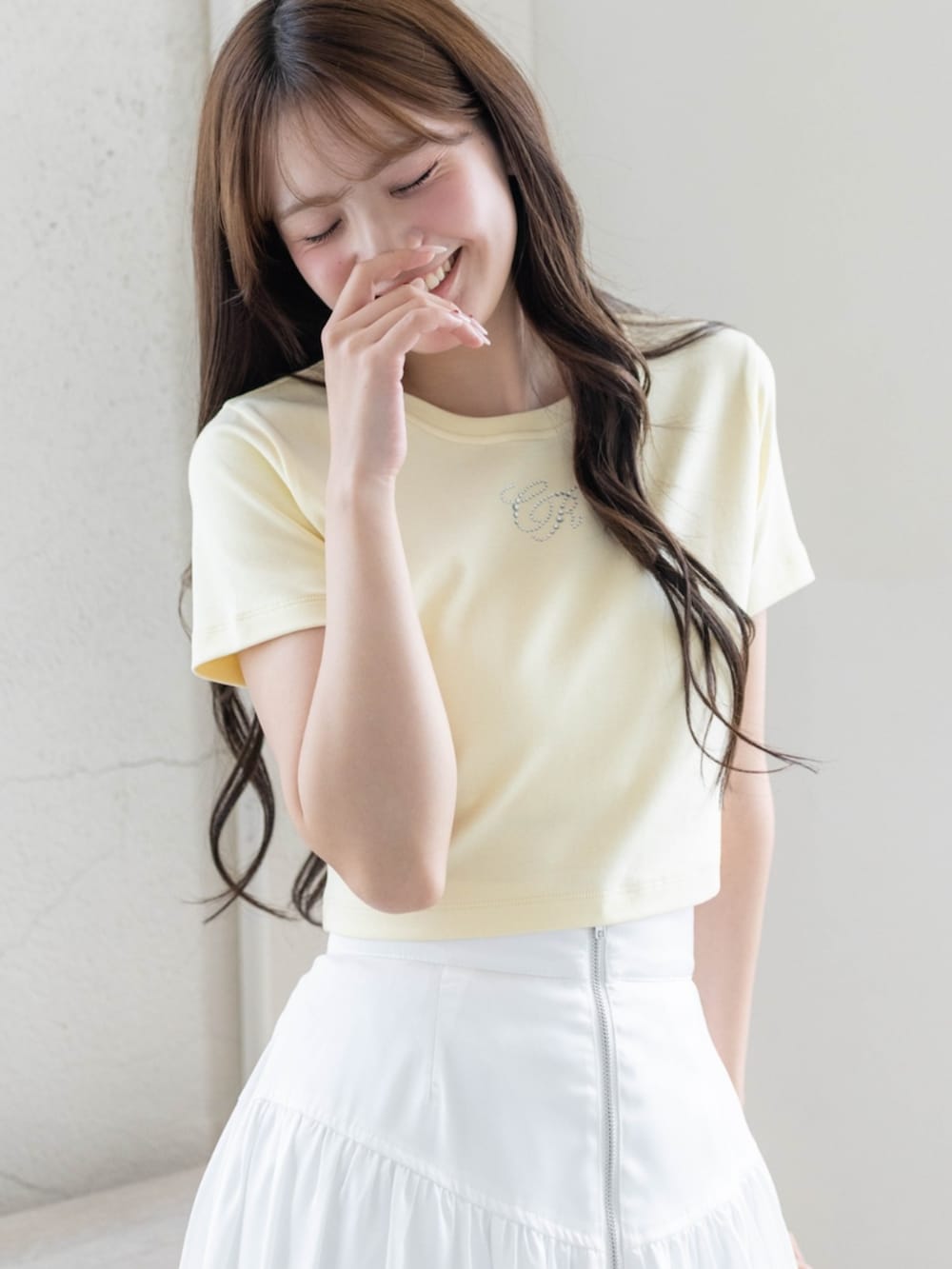 ホワイト系のスカート、ホワイト系のパンプス、イエロー系のTシャツ/カットソーを着用したレディースの夏コーディネートの5枚目の写真
