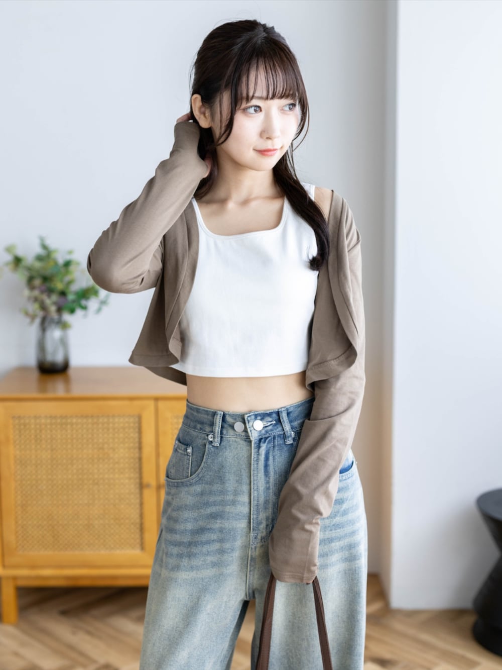 ブラウン系のショルダーバッグ、ブルー系のデニムパンツ、ブラウン系のカーディガン/ボレロを着用したレディースの夏コーディネートの8枚目の写真