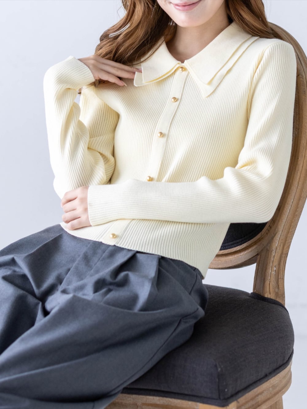 グレー系のスラックス、ブラック系のパンプス、イエロー系のニット/セーターを着用したレディースの秋コーディネートの7枚目の写真