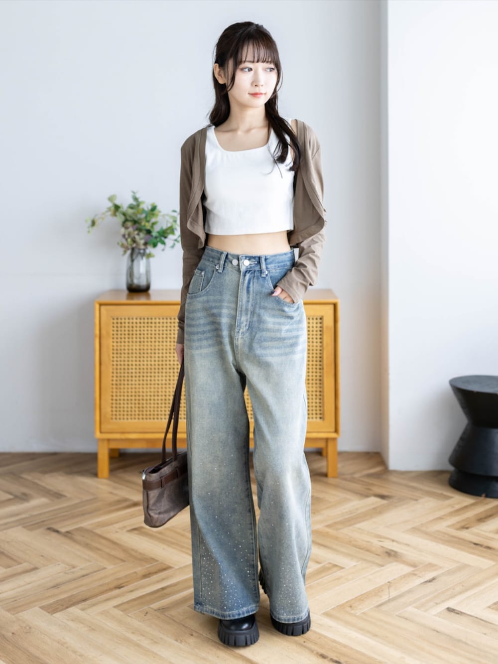 ブラウン系のショルダーバッグ、ブルー系のデニムパンツ、ブラウン系のカーディガン/ボレロを着用したレディースの夏コーディネートの2枚目の写真