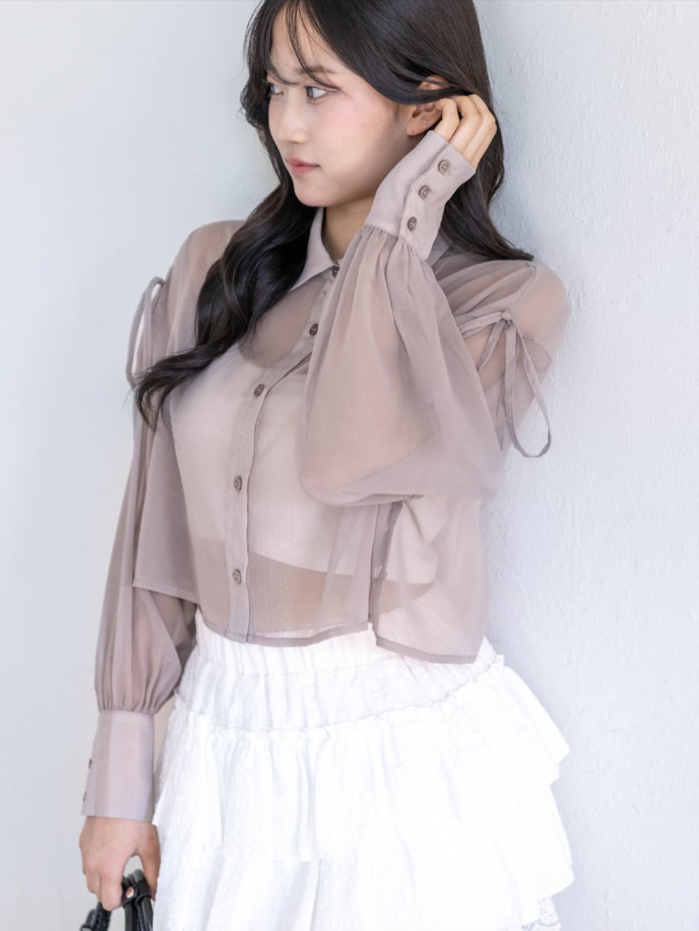 ブラック系のパンプス、ホワイト系のスカート、ブラック系のハンドバッグを着用したレディースの春コーディネートの4枚目の写真