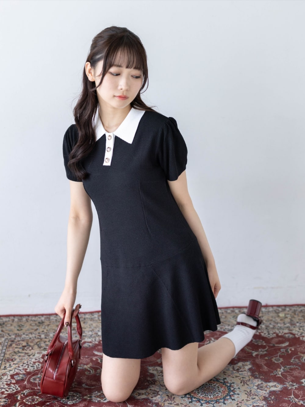 レッド系のパンプス、ブラック系のワンピースを着用したレディースの夏コーディネートの6枚目の写真