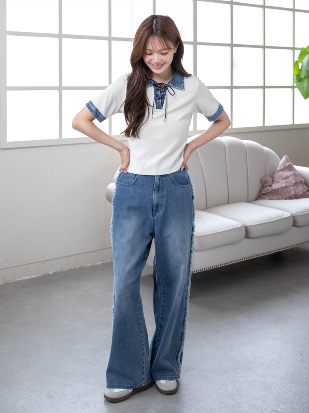 ホワイト系のスニーカー、ホワイト系のTシャツ/カットソー、ブルー系のデニムパンツを着用したレディースの春コーディネートの2枚目の写真
