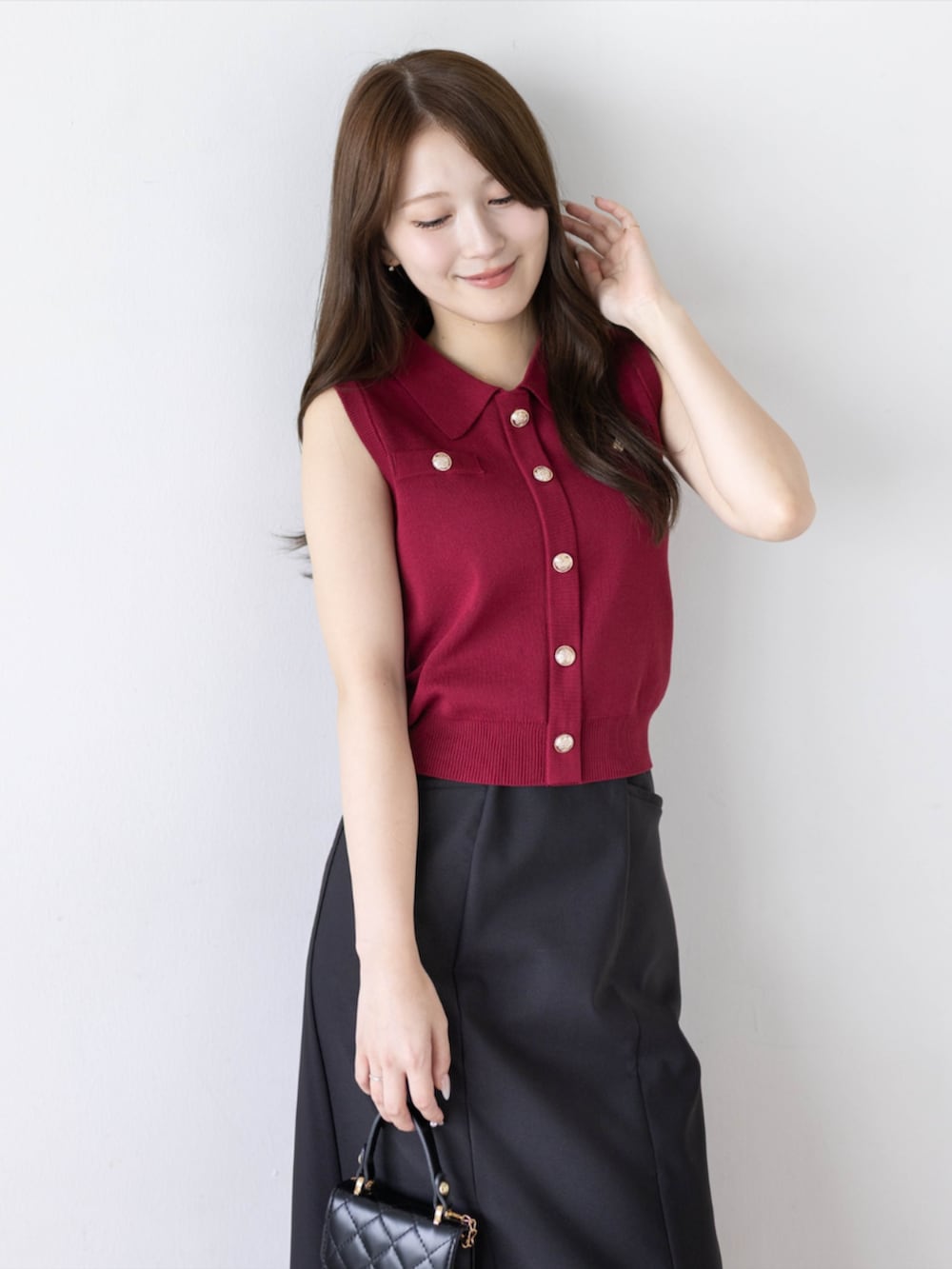 ブラック系のパンプス、ブラック系のスカート、レッド系のニット/セーターを着用したレディースの夏コーディネートの5枚目の写真