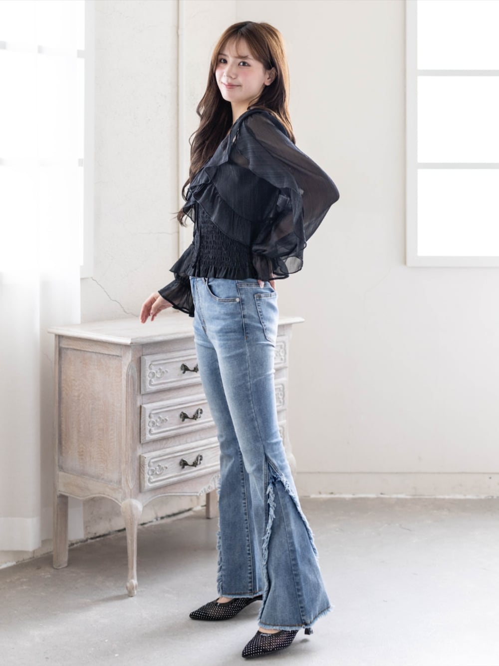 ブルー系のデニムパンツ、ブラック系のパンプス、ブラック系のシャツ/ブラウスを着用したレディースの春コーディネートの3枚目の写真