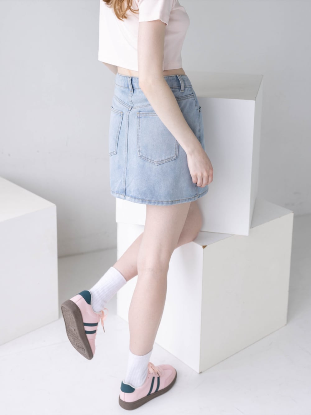 ピンク系のTシャツ/カットソー、ブルー系のデニムスカート、ピンク系のスニーカーを着用したレディースの夏コーディネートの9枚目の写真