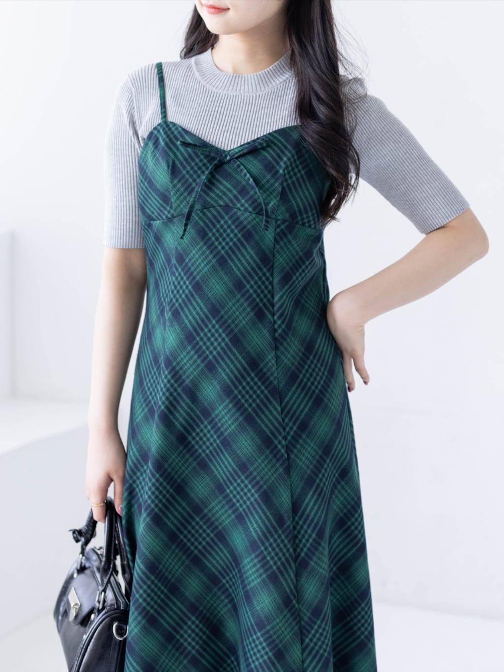 グレー系のニット/セーター、ブラック系のブーツ、グリーン系のワンピースを着用したレディースの春コーディネートの4枚目の写真