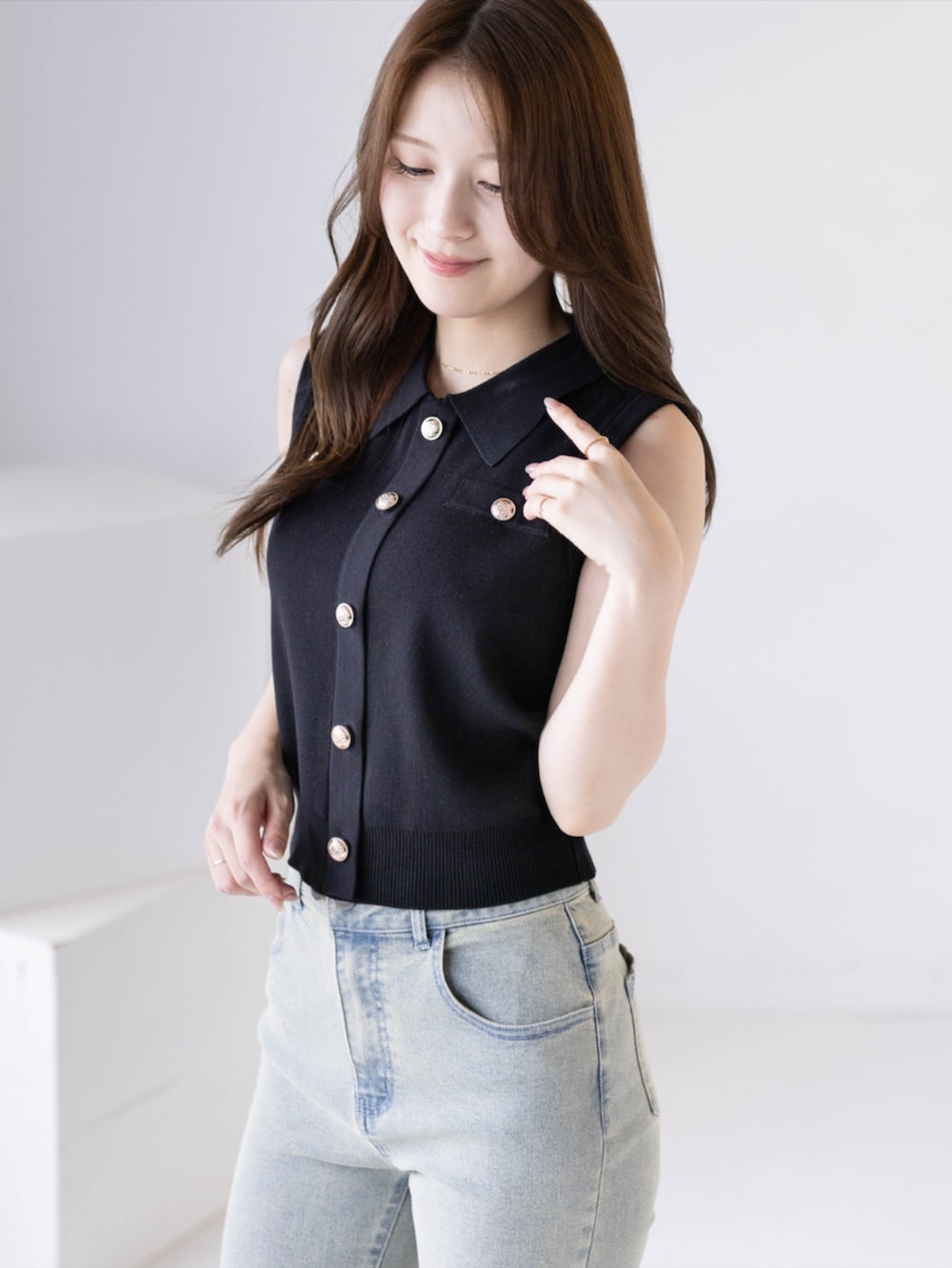 ブラック系のパンプス、ブルー系のデニムパンツ、ブラック系のニット/セーターを着用したレディースの夏コーディネートの3枚目の写真