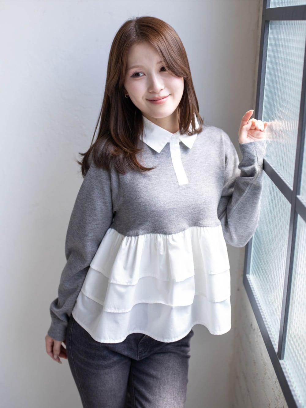 ブラック系のデニムパンツ、ブラック系のパンプス、グレー系のニット/セーターを着用したレディースの秋コーディネートの6枚目の写真