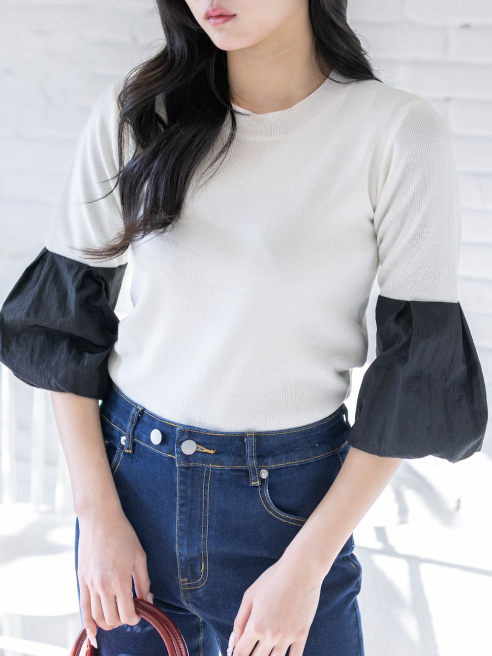 ブラック系のパンプス、ホワイト系のニット/セーター、ブルー系のデニムパンツを着用したレディースの春コーディネートの3枚目の写真