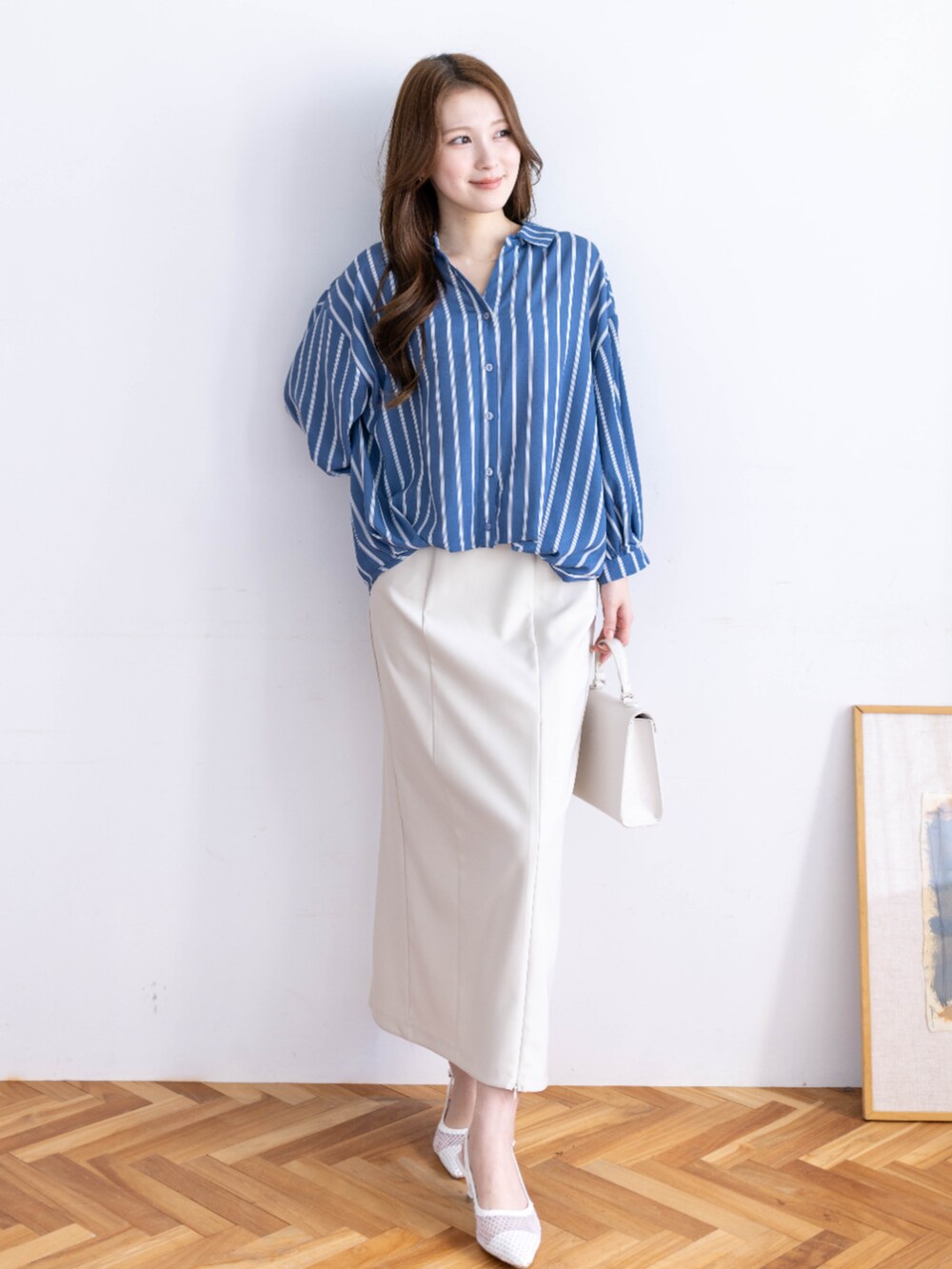 ホワイト系のスカート、ホワイト系のハンドバッグ、ブルー系のシャツ/ブラウスを着用したレディースの冬コーディネートの3枚目の写真