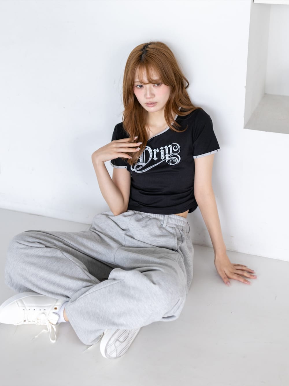 ゴールド系のスニーカー、グレー系のスウェットパンツ、ブラック系のTシャツ/カットソーを着用したレディースの夏コーディネートの3枚目の写真
