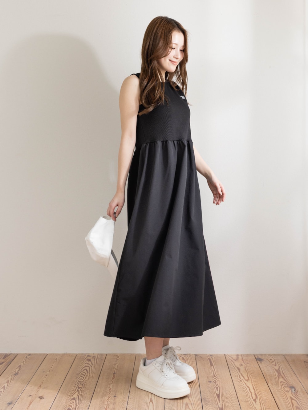 ブラック系のワンピース、ホワイト系のキャップを着用したレディースの春コーディネートの3枚目の写真