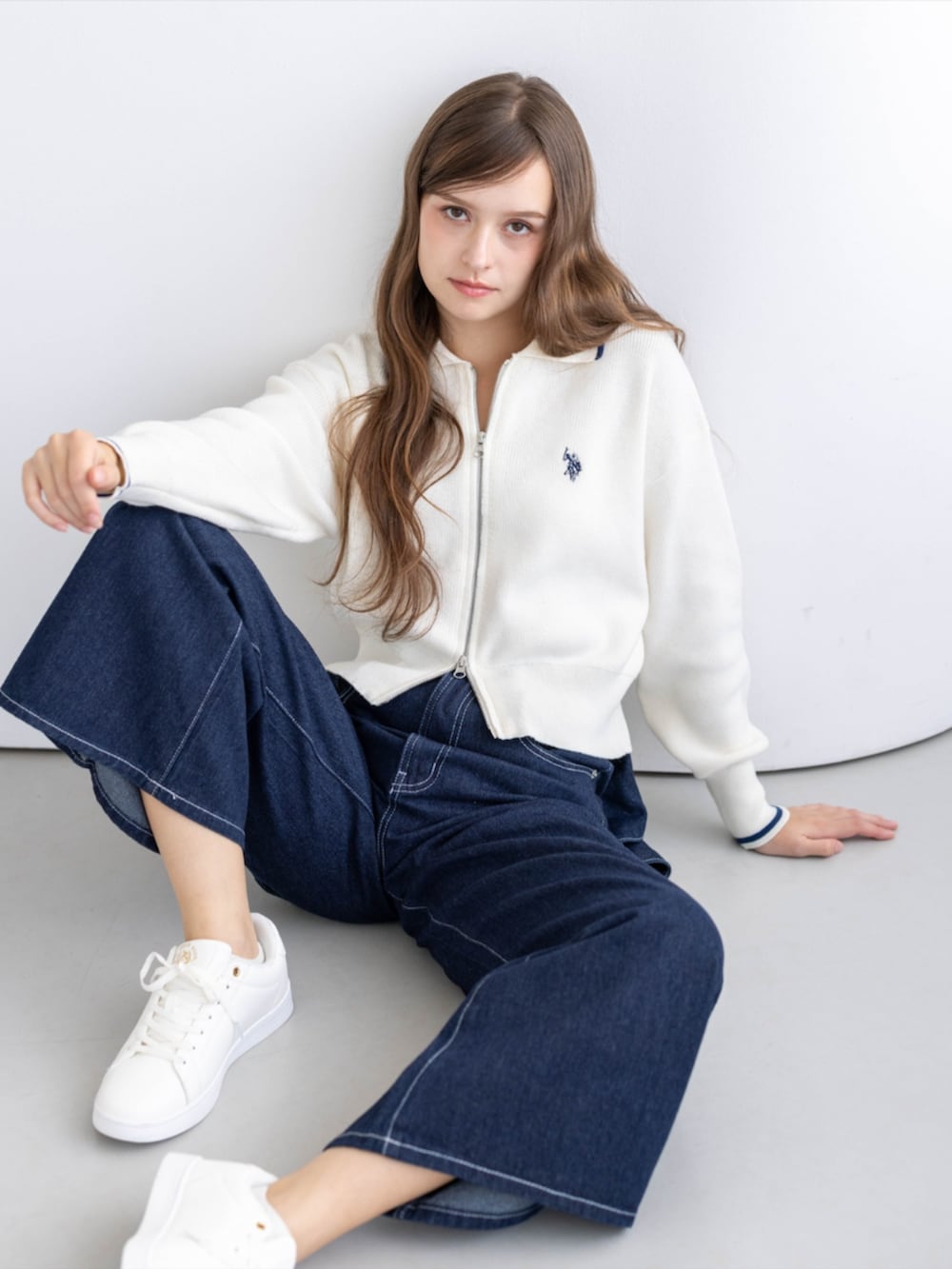 ゴールド系のスニーカー、ブルー系のデニムパンツ、ホワイト系のTシャツ/カットソーを着用したレディースの秋コーディネートの8枚目の写真