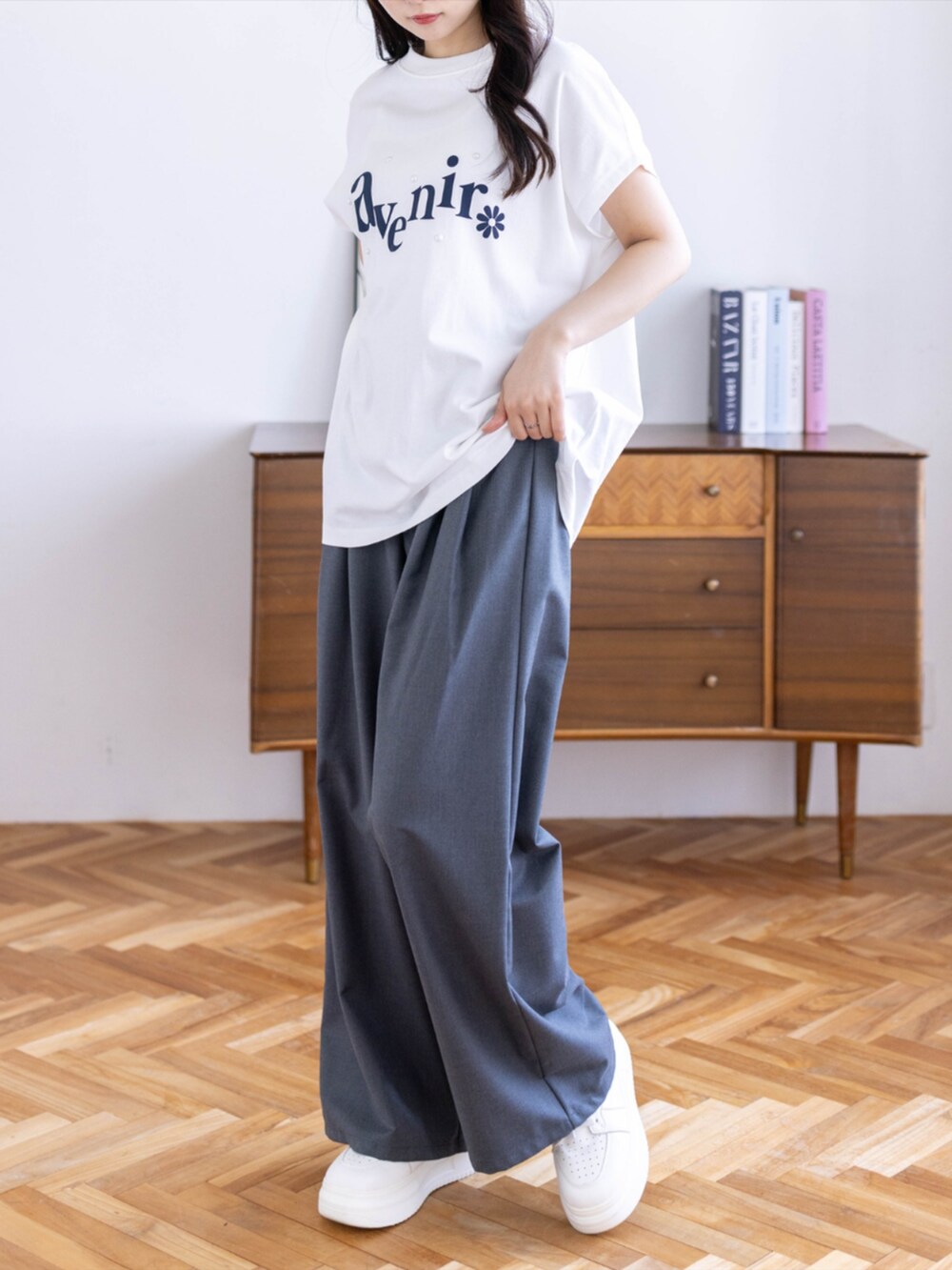 グレー系のスラックス、ホワイト系のTシャツ/カットソーを着用したレディースの春コーディネートの2枚目の写真