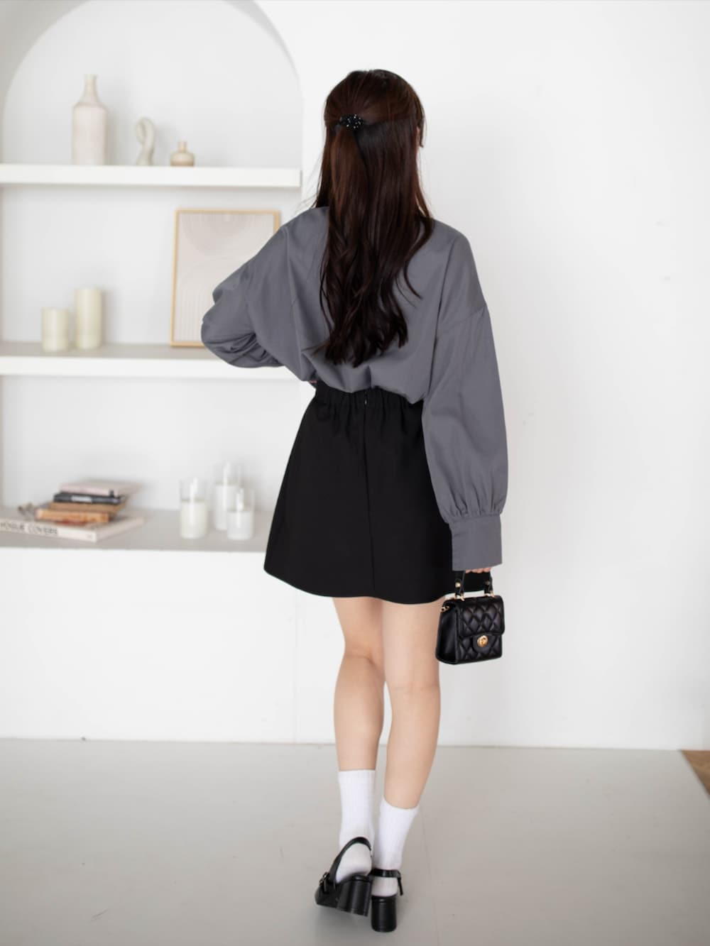 ブラック系のパンプス、グレー系のシャツ/ブラウス、ブラック系のスカートを着用したレディースの夏コーディネートの2枚目の写真