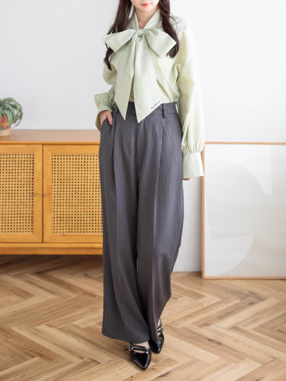 ブラック系のパンプス、グレー系のスラックス、グリーン系のシャツ/ブラウスを着用したレディースの夏コーディネートの4枚目の写真