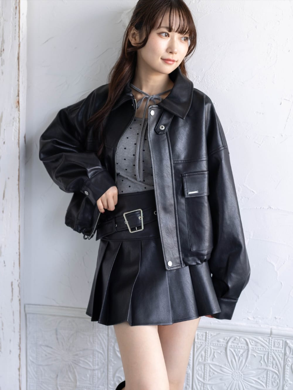 ブラック系のスカート、ブラック系のブーツ、グレー系のTシャツ/カットソーを着用したレディースの秋コーディネートの6枚目の写真